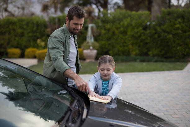 istock Teenage girl and father washing a car 856114708