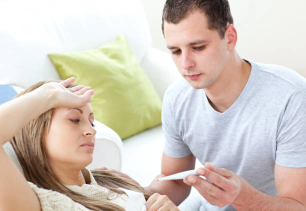 istock Caring man check the temperature of his sick girlfriend with a thermometer 856115028