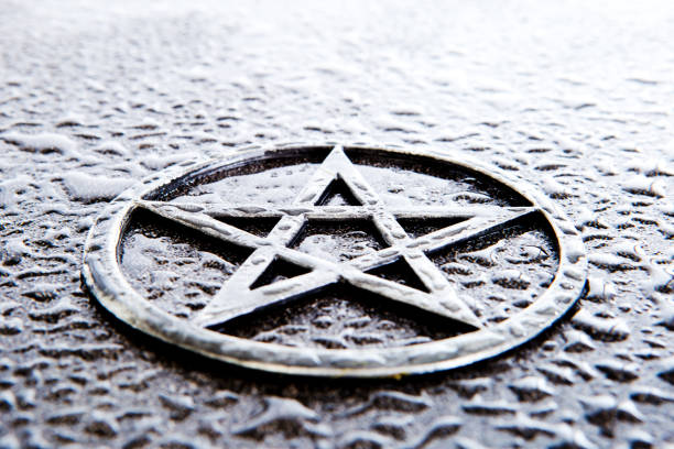 Gray metal pentagram on slate background with water drops - high key - with copy space
