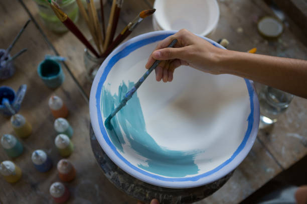 istock Female potter hand painting a bowl 856123298