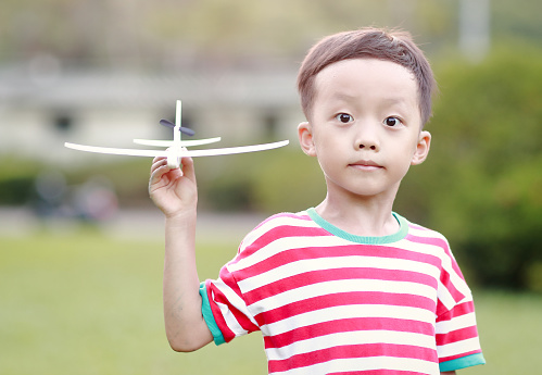 Boy hand holding a paper plane