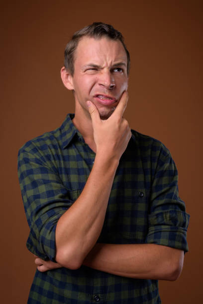 istock Studio shot of man wearing green checkered shirt against colored background 856134014