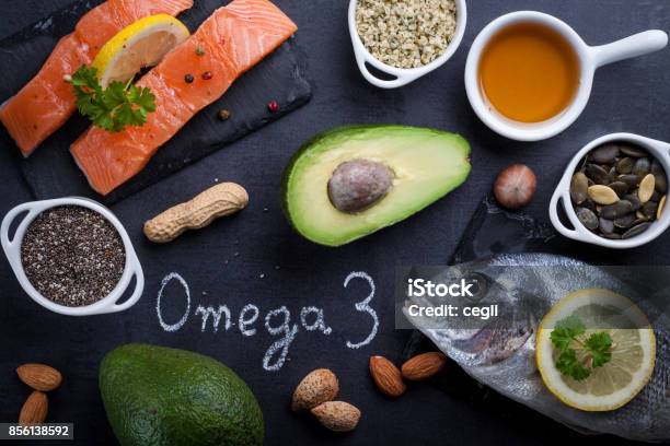 Black Slate Table With Product Rich In Omega 3 And Vitamin D Written Word Omega 3 By White Chalk Stock Photo - Download Image Now