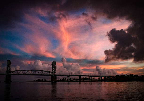 Fiery Wilmington Sky A fiery evening sky over the Cape Fear Memorial Bridge, in downtown Wilmington, NC. cape fear stock pictures, royalty-free photos & images