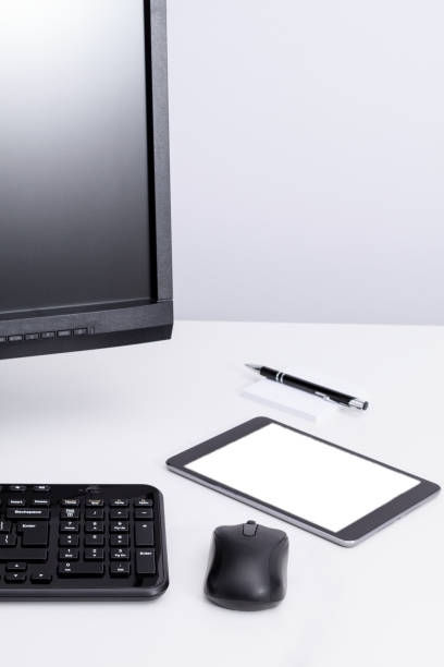 istock Tablet laying on desktop near pc monitor and keyboard in workplace. 856142520