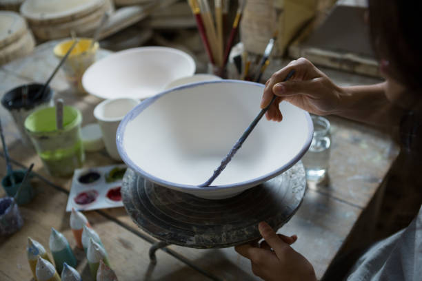 istock Female potter painting bowl 856147898