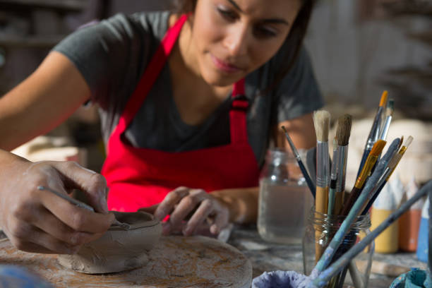 istock Female potter molding a bowl with hand tool 856148192