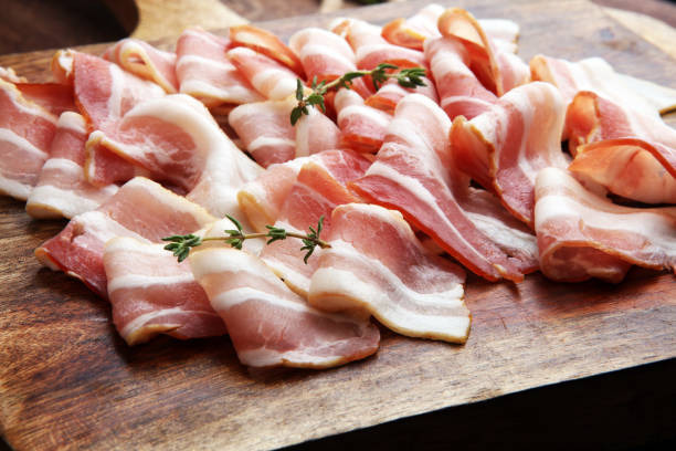 istock Raw sliced bacon with thyme leaves ready for cooking 856153218