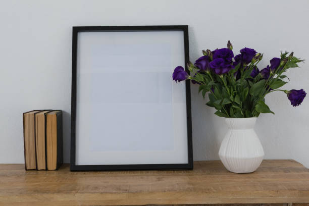 istock Picture frame and flower vase on table 856160070