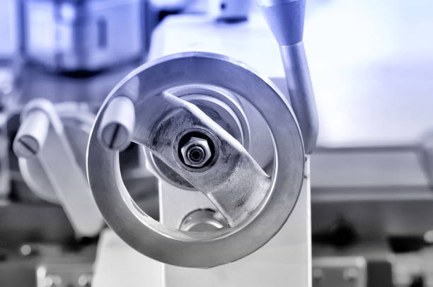 Round metal handle of the lathe. Blue toning. Shallow depth of field, selective focus