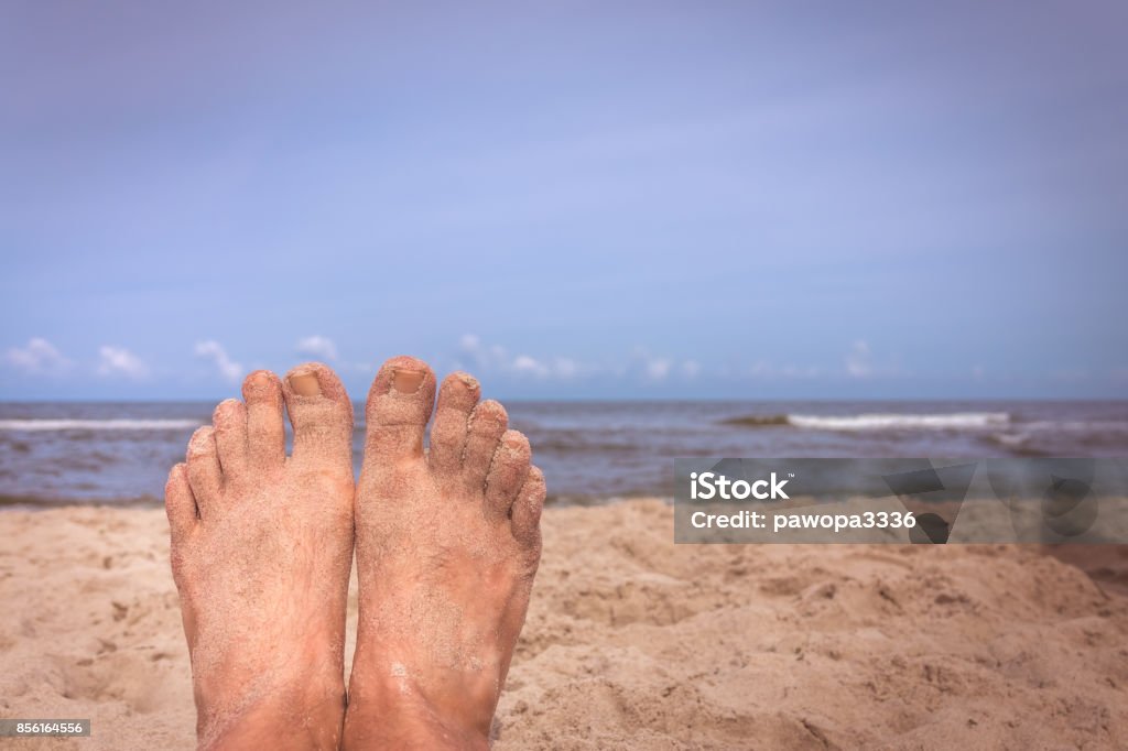 Mans feet on the beach Close up of a feet of a man lying on the beach in summer Adult Stock Photo