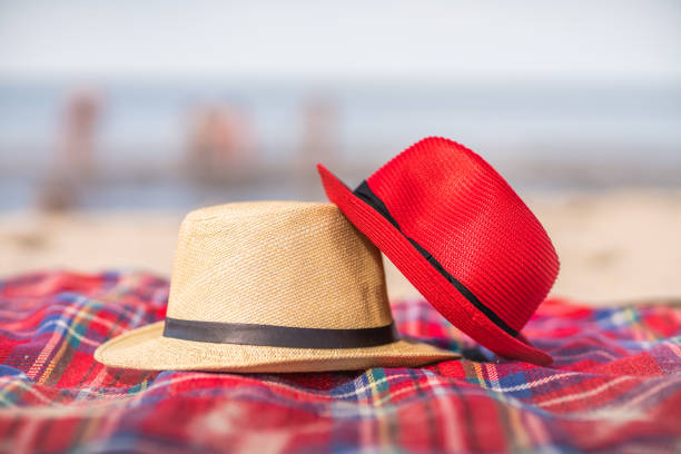 Red and white straw hats on the colorful blanket on the 