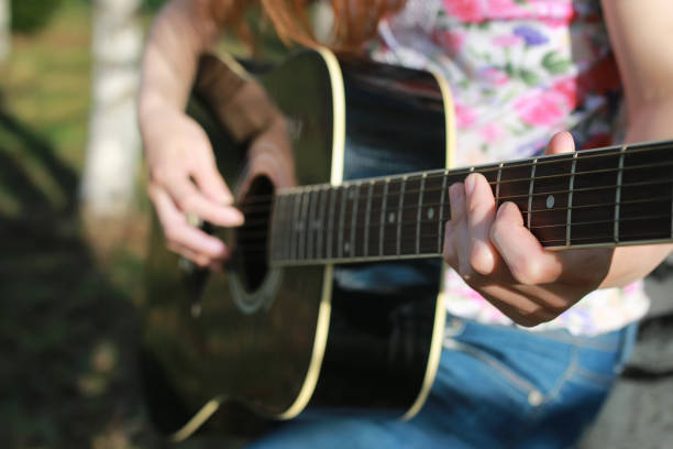 main de femme guitare chaîne extérieure - musical instrument nature outdoors musician photos et images de collection