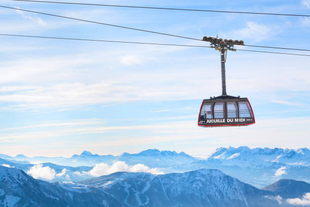 Winter sports travel background with cable car, mountain peaks Chamonix, France - January , 28, 2015: Cable Car from Chamonix to the summit of the Aiguille du Midi and lift station high in the mountains Chamonix, France. aiguille de midi photos stock pictures, royalty-free photos & images