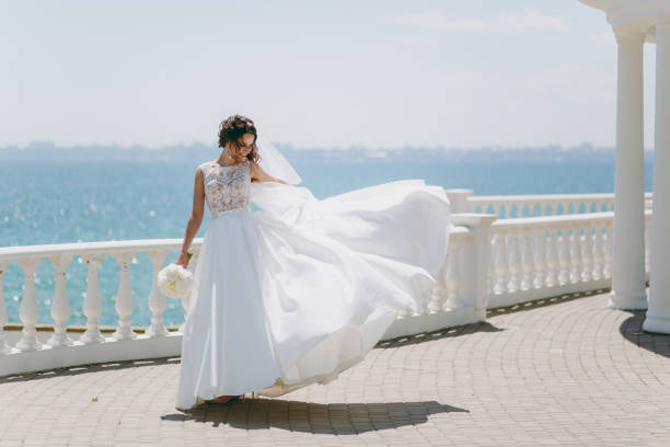 istock Beautiful brunette bride on a walk by the sea 856174310