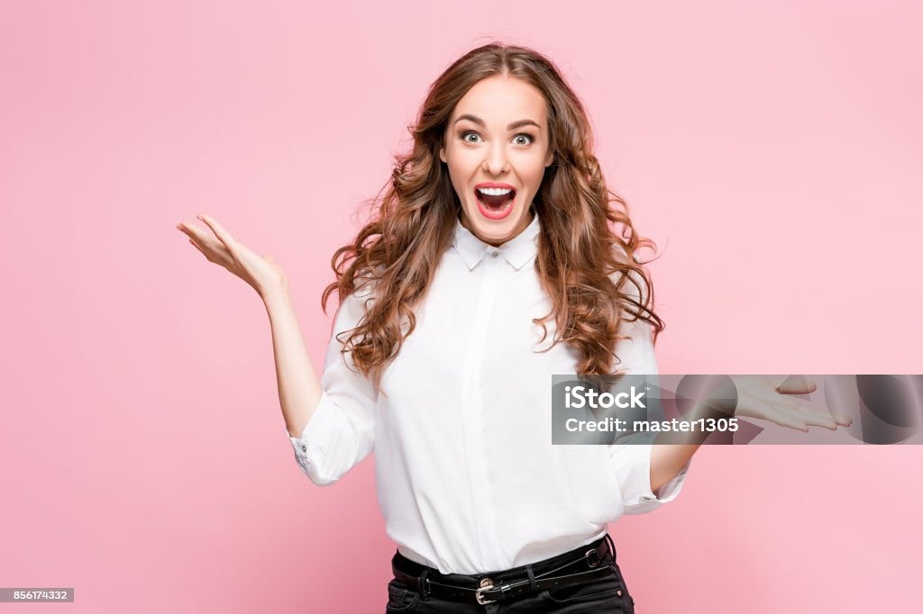 Surprised happy beautiful woman looking in excitement Surprised happy beautiful woman looking in excitement. Studio shot on pink background Women Stock Photo