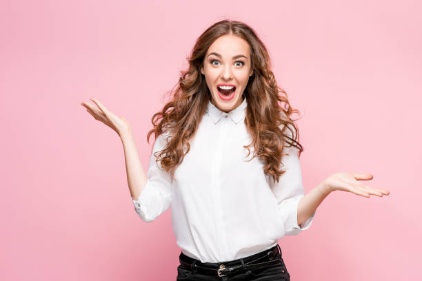 Surprised happy beautiful woman looking in excitement Surprised happy beautiful woman looking in excitement. Studio shot on pink background facial expression surprise stock pictures, royalty-free photos & images