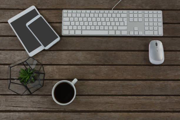 istock Digital tablet, mobile phone, mouse, pot plant, keyboard and black coffee on wooden plank 856177476