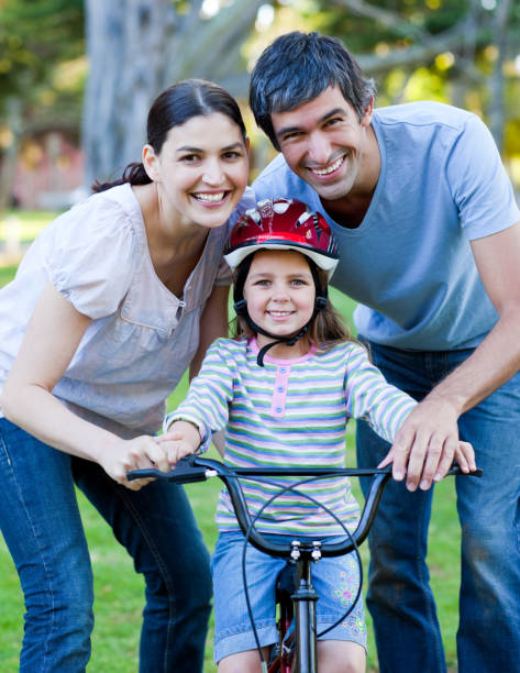 istock Happy family looking at the camera while riding a bike 856178342