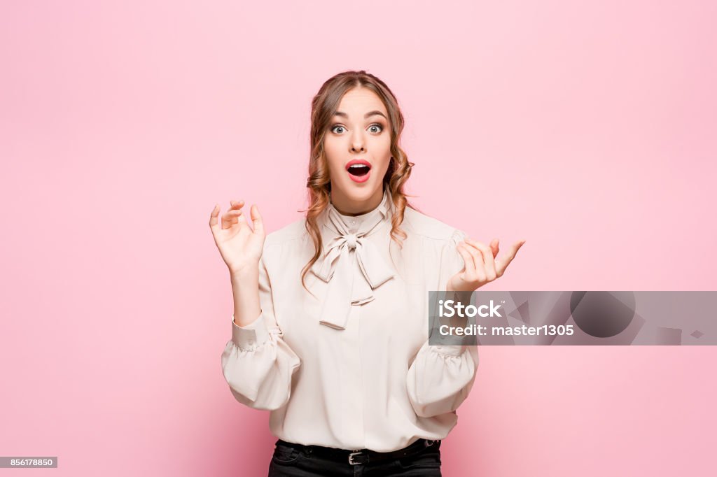 Surprised happy beautiful woman looking in excitement Surprised happy beautiful woman looking in excitement. Studio shot on pink background Surprise Stock Photo