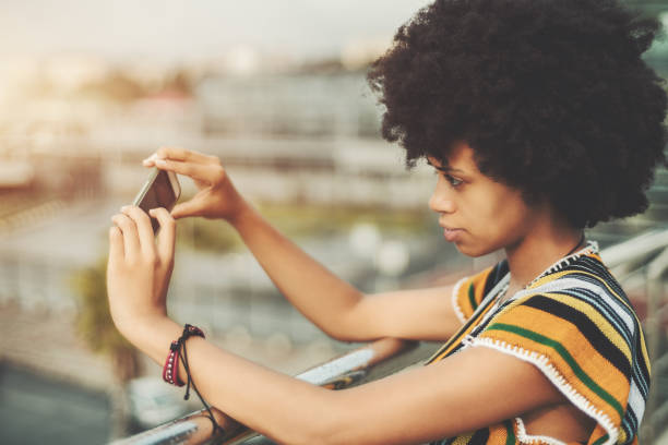 istock Charming black girl with disco hair making piture on cellphone 856181704
