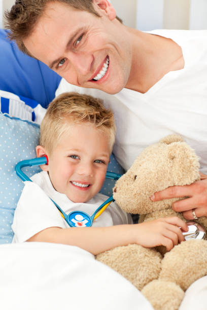 istock Handsome father and his sick son playing with a stethoscope 856184452