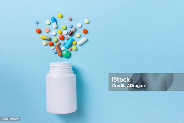 Assorted Pharmaceutical Medicine Pills Tablets And Capsules And Bottle On Blue Background Copy Space For Text Stock Photo - Download Image Now