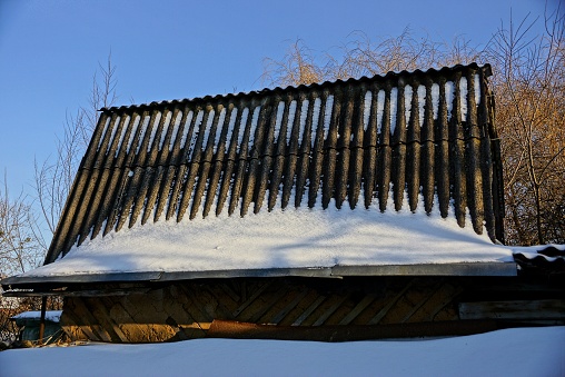 Slate roof under snow on a sunny day