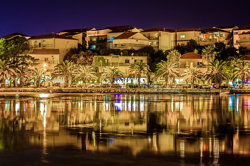 Night waterfront view at small town in suburb of town Split, Stobrec townscape, Croatia. Long exposure.