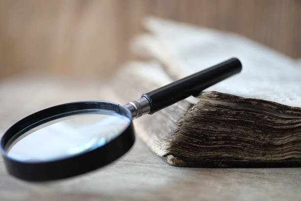 istock Old books on a wooden table and magnifier 856189612