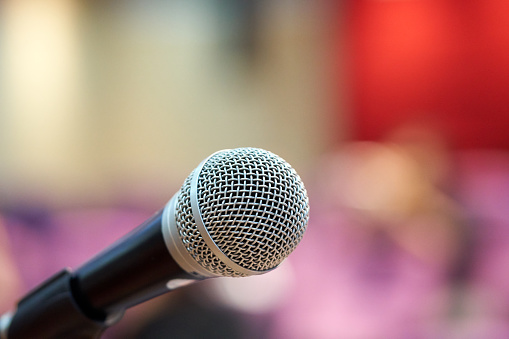 Microphone over the Abstract blurred photo of conference hall or seminar room background