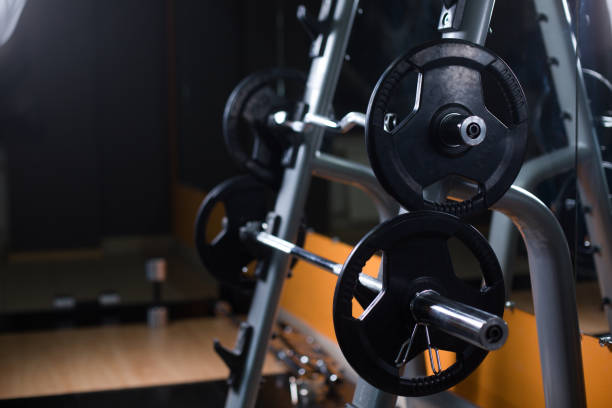 istock Two long barbells on a stand. Barbell holder on a blurred gym background. Heavy, huge black dumbbells. Sport equipment. 856193902