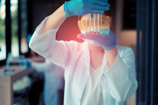 mujer científico con gafas de trabajo investigación y conduce experimentos compuestos de síntesis en el laboratorio y el tubo de ensayo - laboratory assistant healthcare and medicine chemistry fotografías e imágenes de stock