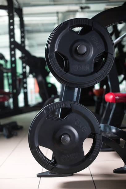 istock Two long barbells on a stand. Barbell holder on a blurred gym background. Heavy, huge black dumbbells. Sport equipment. 856200588