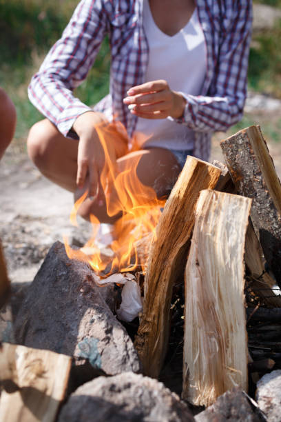 istock Female camper kindling to start a campfire, bonfire close-up. Man kindles a fire. Fire in nature. Bonfire in the forest. 856203884