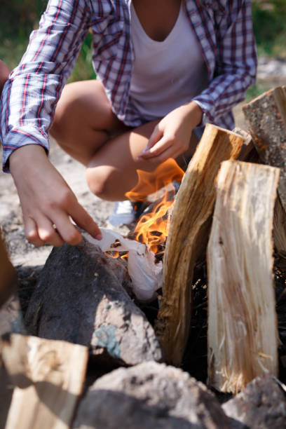 istock Female camper kindling to start a campfire, bonfire close-up. Man kindles a fire. Fire in nature. Bonfire in the forest. 856204150