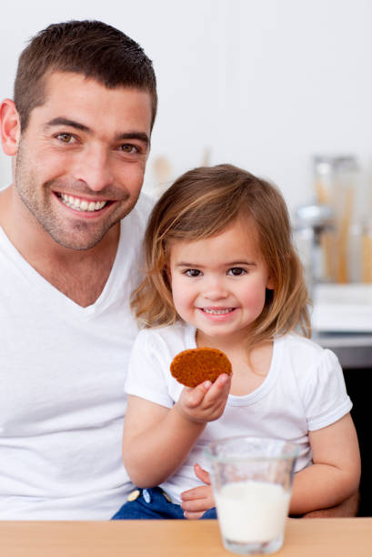 istock Father and daughter eating biscuits with milk 856215934
