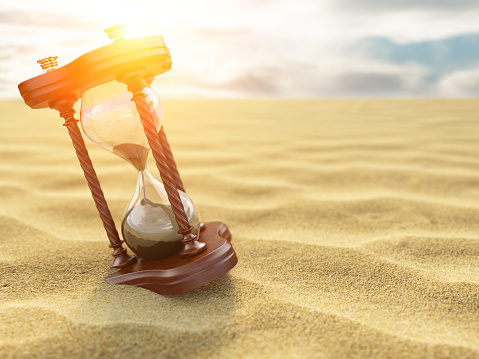 Hourglass clock on sand of desert background. 3d illustration