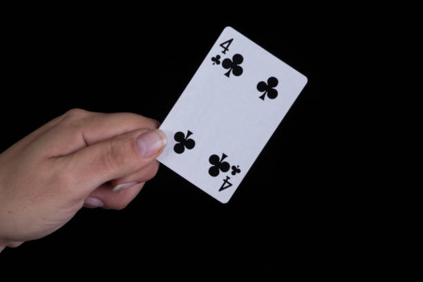istock Hand holds a black four of clubs card 856230672