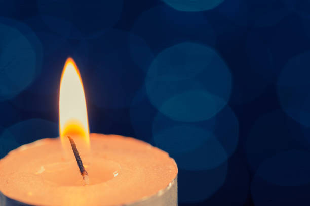 istock Lit candle with blue bokeh 856234728