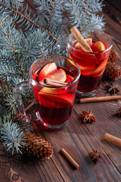 istock Two glasses of red tea for Christmas. Aromatic tea next to pine tree branch on a table background. 856237308