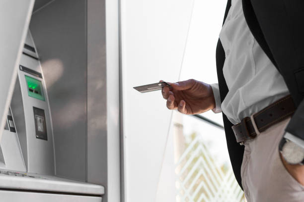 istock Businessman holding card at an ATM 856240878