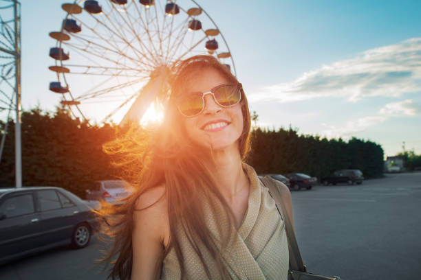 istock woman smiling cheerfully in front of a ferris wheel 856242168