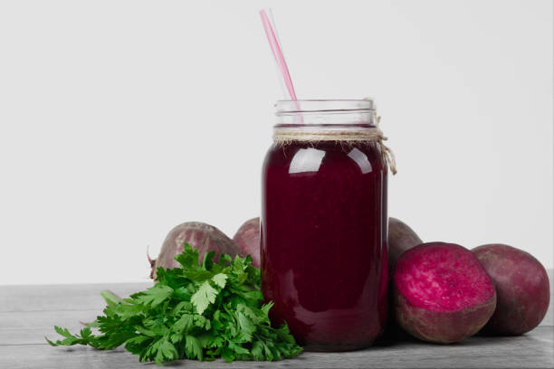 istock Beetroot juice. A bottle of vegetable cocktail isolated on a white background. Beets and greens on a table. Copy space. 856246464