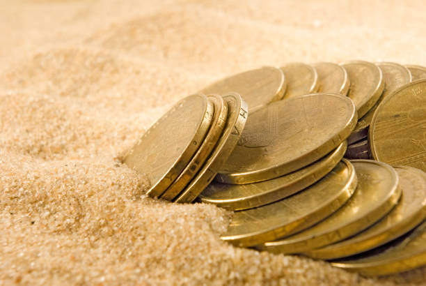 istock image of coins on the sand close up 856252840