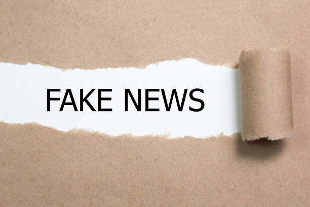 istock FAKE NEWS word written under torn paper. 856253316