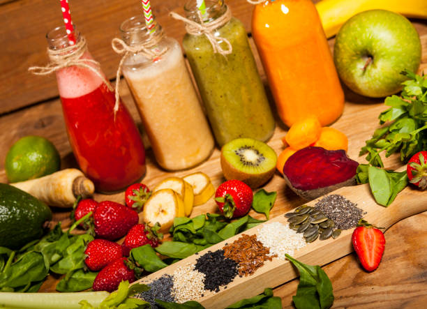 istock Assortment of fruit and vegetable smoothies in glass bottles with straws 856253424