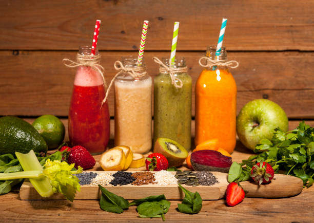 istock Assortment of fruit and vegetable smoothies in glass bottles with straws 856253462