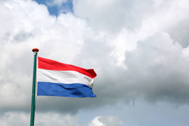 istock flag of the Netherlands with red white and blue and cloudy sky 856260124