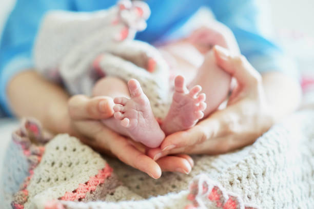 istock Mother holding newborn baby's feet in her hands 856266828